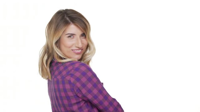 portrait from back of charming woman 30s with dyed blond hair turning around on camera with brilliant smile being flirty over background copy space. Concept of emotions