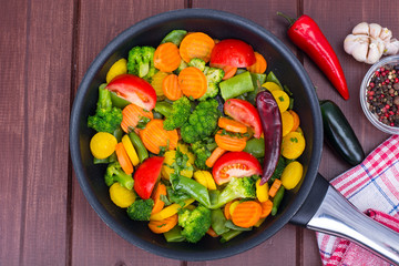 Carrots, broccoli, tomatoes  in  frying pan. Vegetarian menu