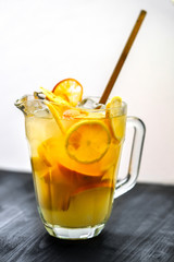 homemade orange lemonade in jug on wooden table