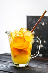 homemade orange lemonade in jug on wooden table