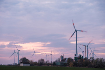 wind turbines on a field during sunset