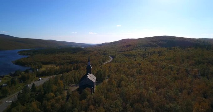 Arctic church, Cinema 4k aerial view over utsjoki church, near mantojarvi lake and utsjoki town, on a sunny autumn day, in Lapland, Lappi, Finland
