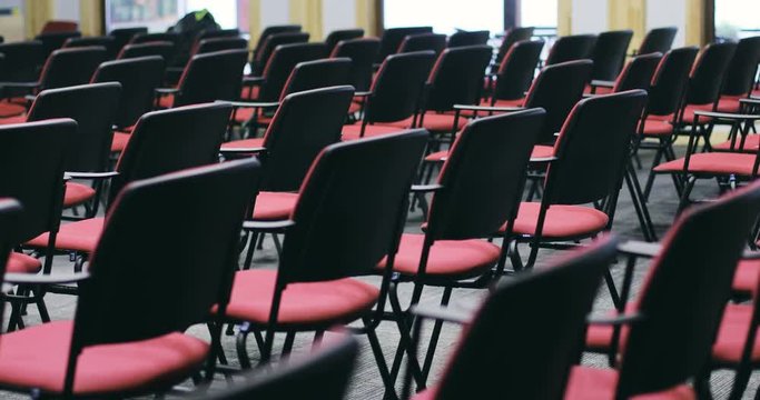 empty rented conference hall red chairs seats vacant place back view moving along neat rows rental modern meeting room educational workplace presentation nobody indoors public space seating seat