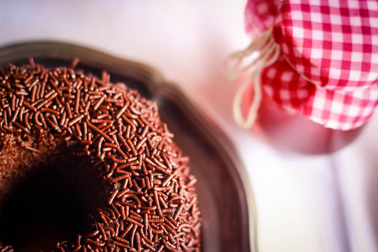 Homemade chocolate cake with jar of jam next to it