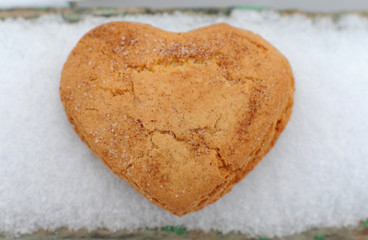 Homemade cookies with sugar and cinnamon in the form of hearts on a background of snow