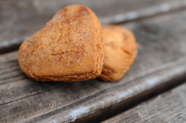 Homemade cookies with sugar and cinnamon in the form of hearts on a wooden background