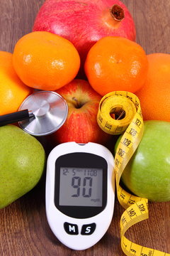 Glucometer with result of measurement sugar level, centimeter and fresh fruits, diabetes concept