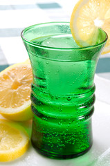 Summer Drink in Green Glass with Bubbles and Lemon Slices
