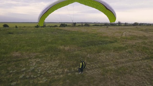 Paraplane, paraglider in the air aerial shot. Extreme man flies on a paraglider over a cliff near the sea. Extreme life.