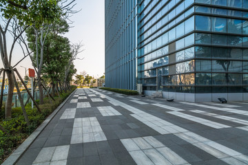 empty pavement and modern buildings in city.