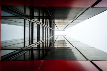 Fototapeta na wymiar Urban Geometry, looking up to glass concrete steel building. Modern architecture. Abstract architectural design. Inspirational, artistic image. Industrial design.