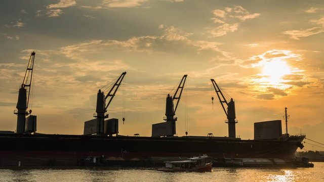  Cargo ship are loading sugar into the bilge with sunset.