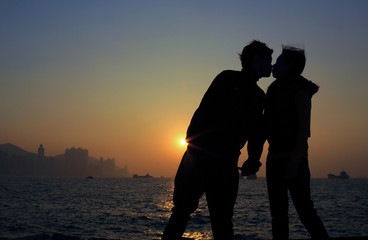 boy kiss his girl in valentines day under the city of sunset