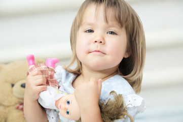 Little girl with doll playing happy smiling