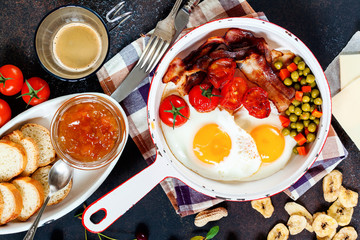 Breakfast including coffee, fried egg , becon. nut , muesli and bread . Top view