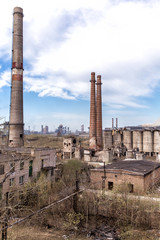Fototapeta na wymiar Industrial landscape. Destroyed and abandoned shops of cement and boiler-radiator plant