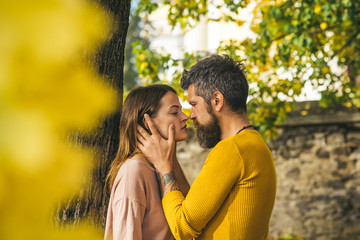 autumn happy couple in love with yellow tree leaves