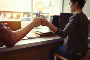Teamwork putting their hands together,Businesswoman holding light bulb on her hands,join hands partnership and idea concept.