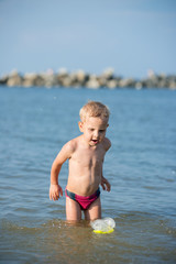Little boy with snorkel by the sea. Cute little kid wearing mask and flippers for diving at sand tropical beach. Ocean coast.