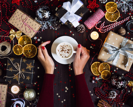 Woman hands holding coffee cup drink christmas holiday gift box on decorated festive table