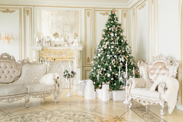 Luxury apartment decorated for christmas. Xmas tree with presents underneath in living room