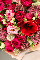 beautiful bouquet of mixed flowers into a vase on wooden table