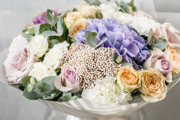 beautiful bouquet of mixed flowers into a vase on wooden table