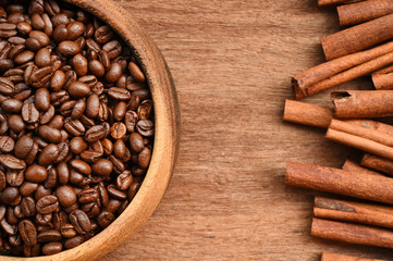 Close up of coffee beans in wooden bowl and cinnamon for background