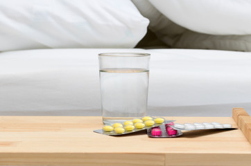 Medicine and water on wood table