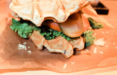 Tasty burgers on wooden table