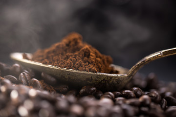 Roasted coffee poured into an old silver spoon.