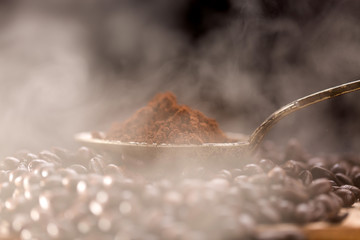 Roasted coffee poured into an old silver spoon.
