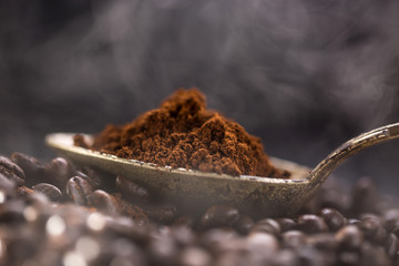 Roasted coffee poured into an old silver spoon.