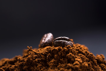 pile of ground coffee, and at the top several whole coffee beans.