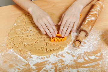 European woman hands with healthy clean wich cook Christmas ginger biscuit in the kitchen. Happy mom 30-35 years roll out dough and cut out cookies at home.