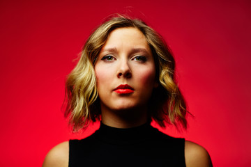 Fototapeta premium young blond woman against red background