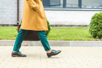 woman in yellow coat walking in park