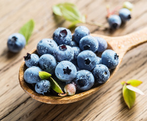 Blueberries in the wooden spoon on the table.