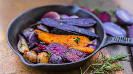 Baked vegetables with herbs in a cast iron pan.
