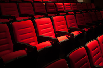 Red seat in the movie theater. Blurry background.