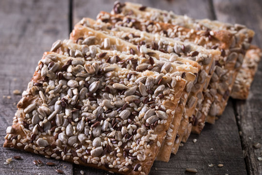 Crunchy crispbread on a wooden background. Healthy snack: cereal crunchy multigrain cereal flax seed ,sesame, sunflower seeds protein bread bar.