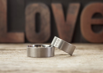 Platinum wedding rings in front of word Love