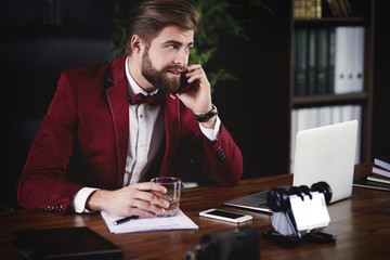 Businessman talking by phone in his office