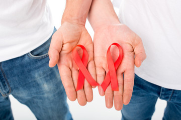 gay couple holding aids ribbons