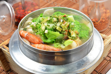 Japanese noodle dish nabeyaki udon with shrimp , egg and vegetables.