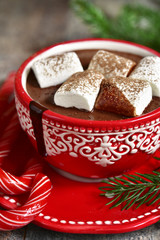 Homemade spicy christmas hot chocolate with marshmellow  in a red cup.