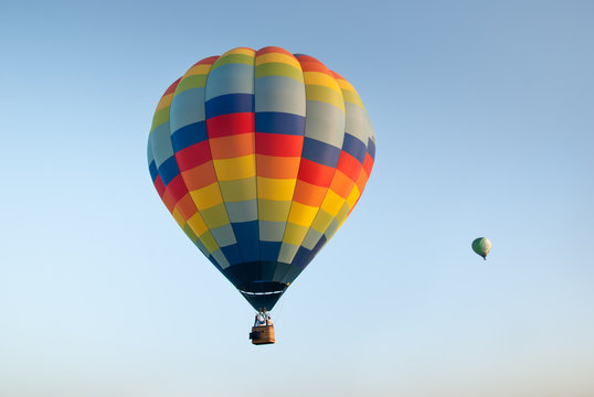 Two colorful hot air balloons on blue sky background