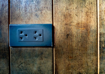 Electrical power outlet in vintage style on old wooden wall at home