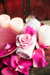 Spa settings with roses. Fresh roses and rose petals in a bowl of water and various items used in spa treatments