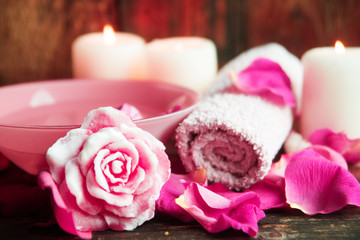 Fototapeta na wymiar Spa settings with roses. Fresh roses and rose petals in a bowl of water and various items used in spa treatments